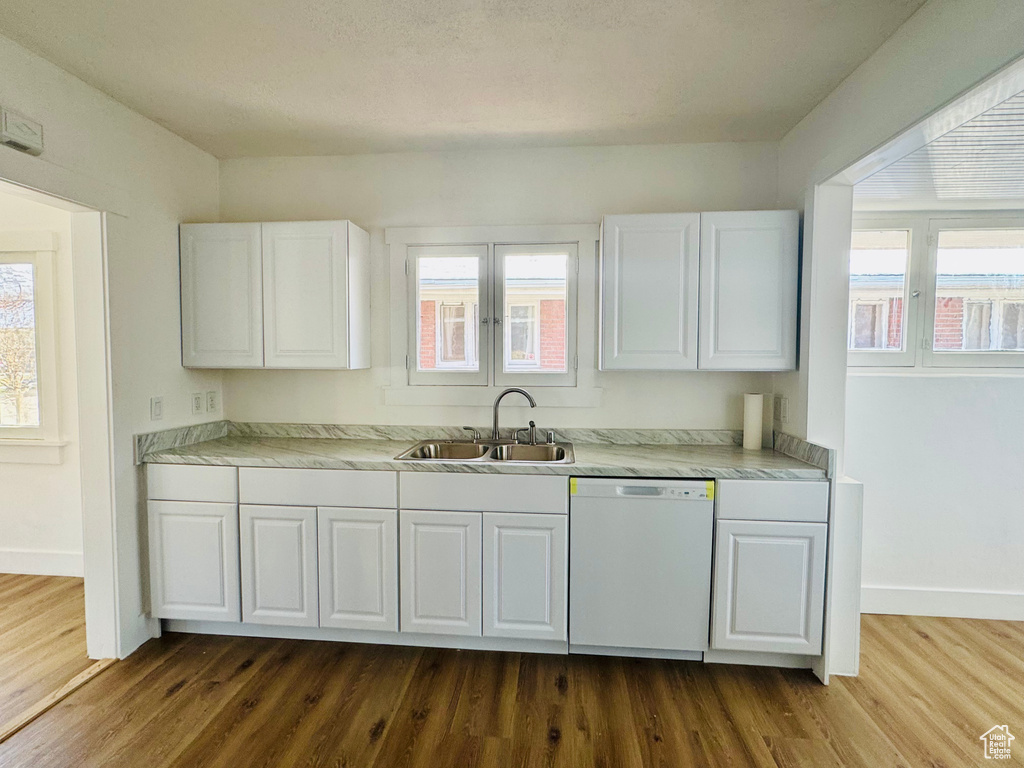 Kitchen featuring a sink, baseboards, dark wood-style floors, and white dishwasher