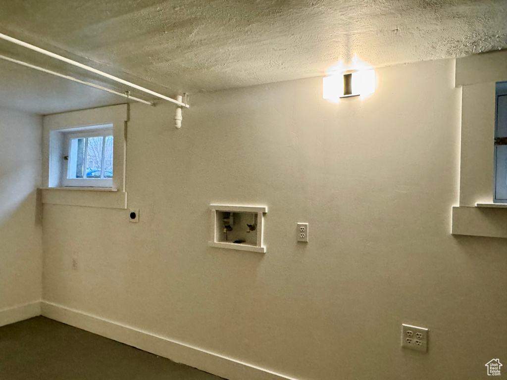 Laundry room featuring washer hookup and a textured ceiling