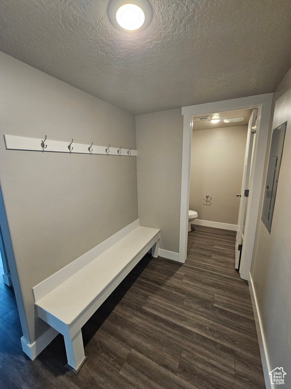 Mudroom featuring dark hardwood / wood-style floors, electric panel, and a textured ceiling