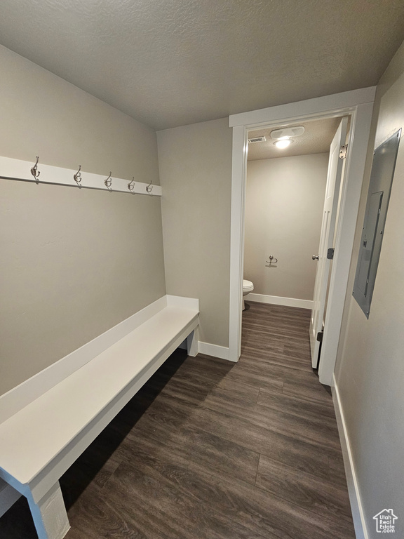 Mudroom featuring dark hardwood / wood-style floors, electric panel, and a textured ceiling