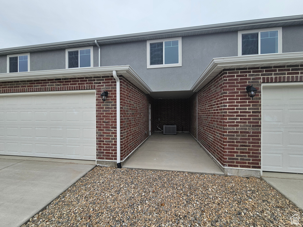 View of front of home with cooling unit and a garage