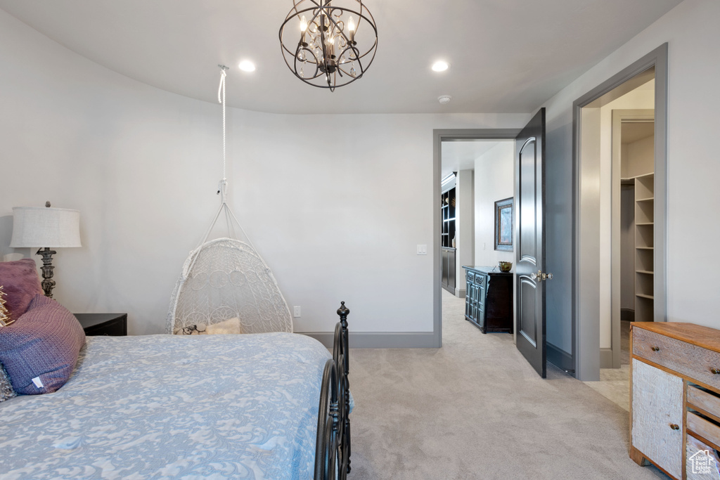 Bedroom with light colored carpet and a notable chandelier