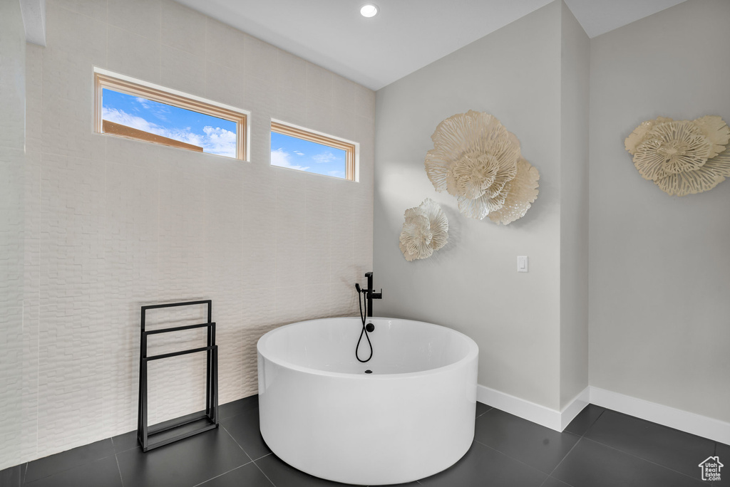 Bathroom with a bathing tub and tile patterned flooring
