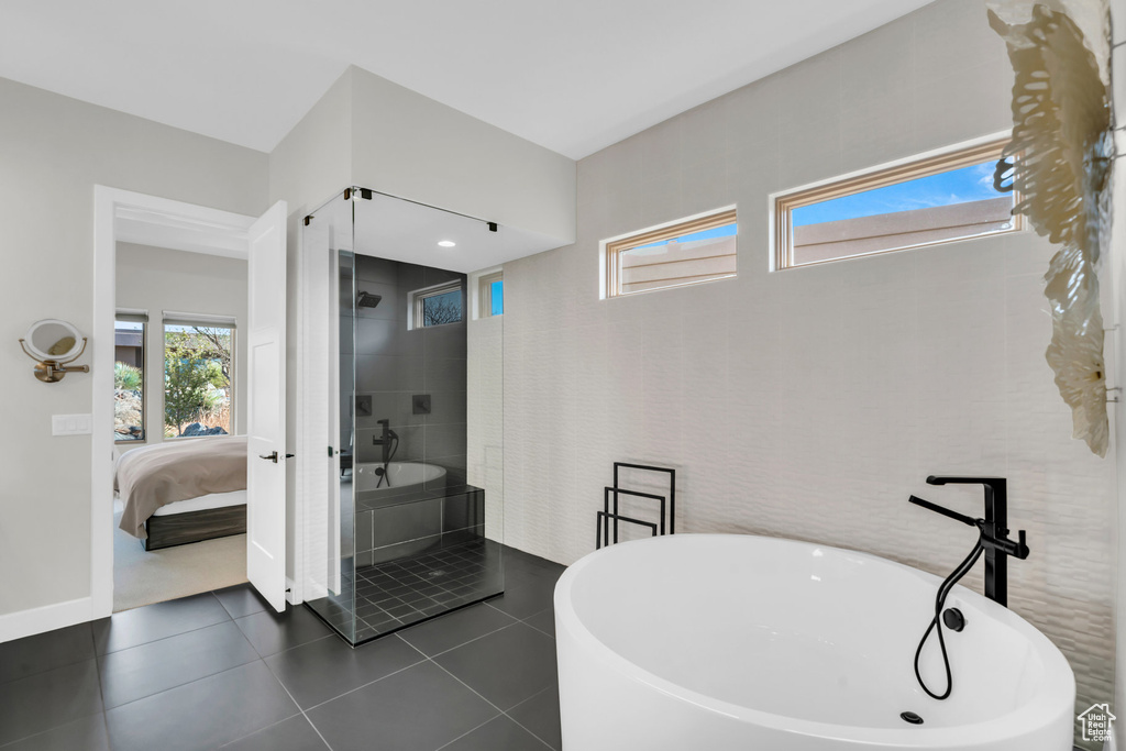 Bathroom featuring tile patterned flooring and separate shower and tub
