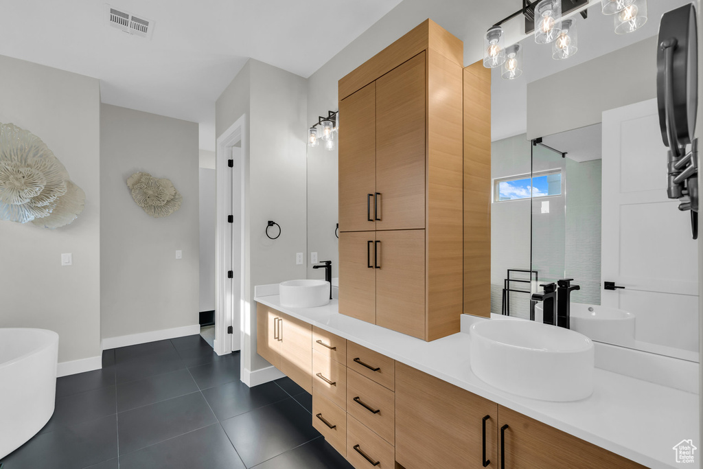Bathroom with tile patterned floors, vanity, and a bath