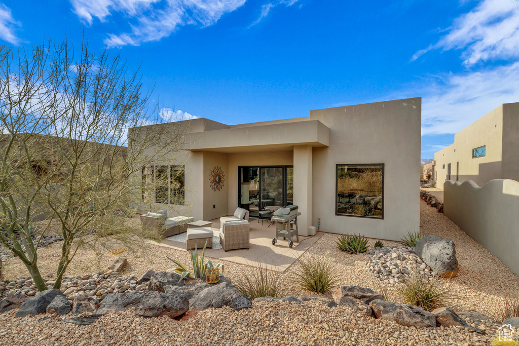 Rear view of property featuring an outdoor living space and a patio area