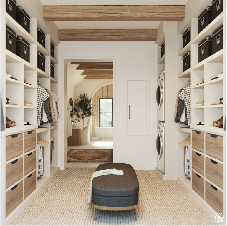 Interior space featuring stacked washer / drying machine and light colored carpet