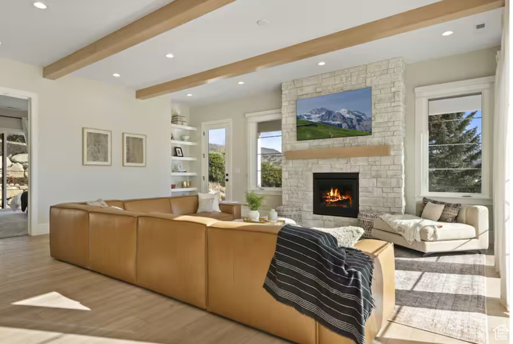Living room featuring beam ceiling, wood finished floors, a fireplace, recessed lighting, and baseboards