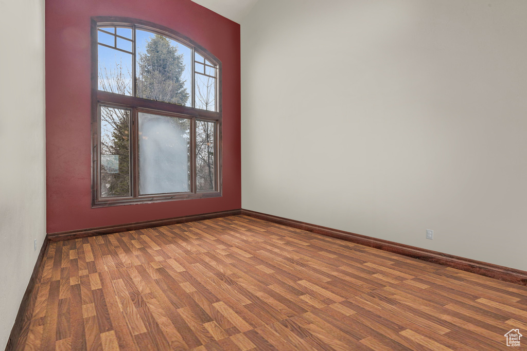 Unfurnished room with wood finished floors and baseboards