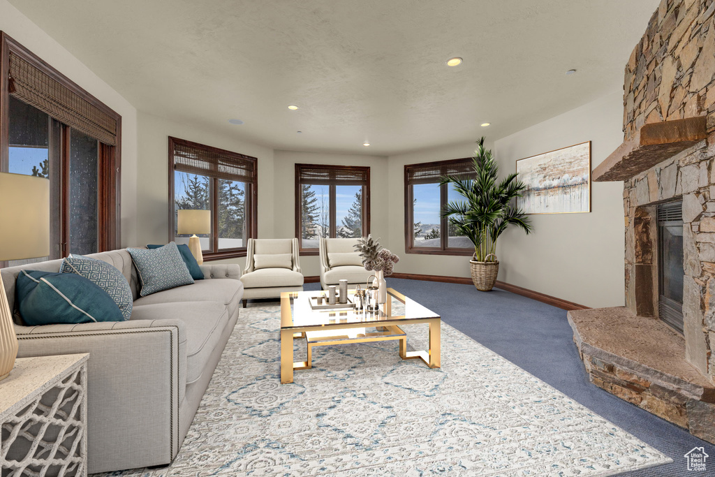 Living room with carpet floors, a stone fireplace, and recessed lighting