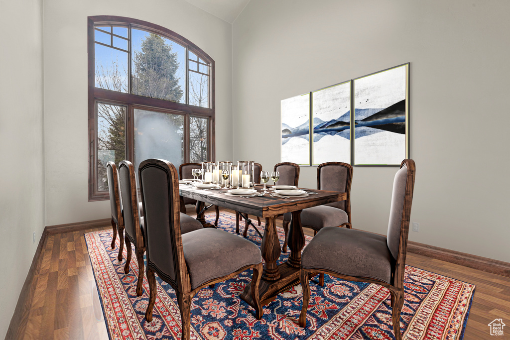 Dining area with wood finished floors and high vaulted ceiling