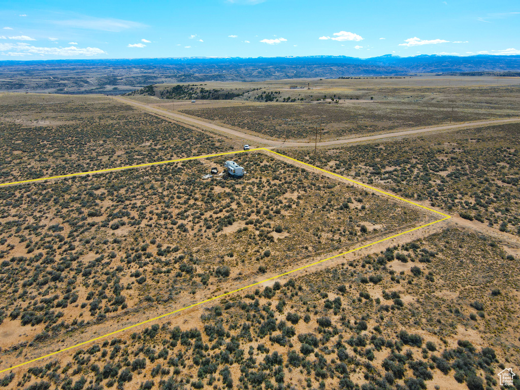 Aerial view of sparsely populated area featuring property parcel outlined and a mountainous background