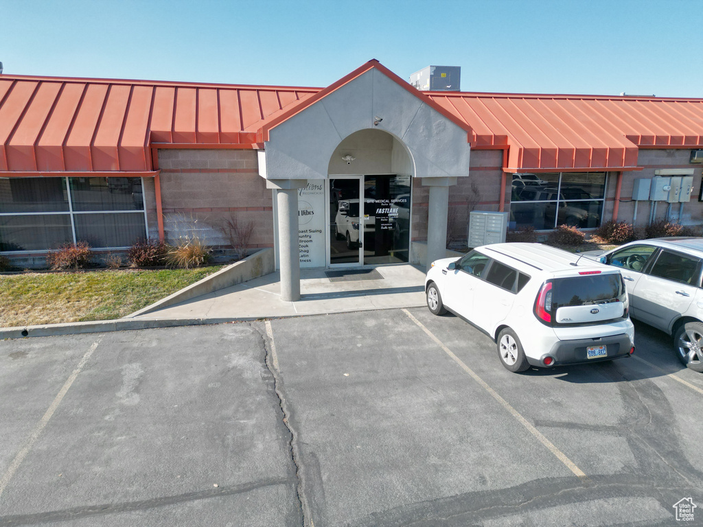 View of building exterior featuring central AC unit