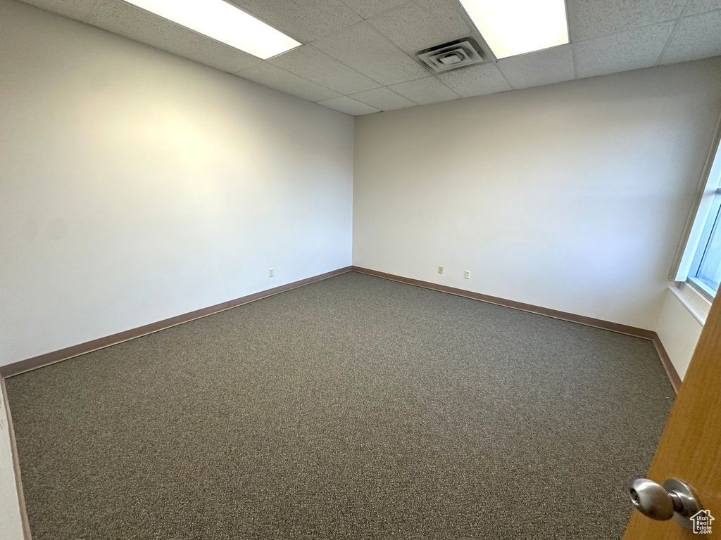 Spare room with a paneled ceiling and carpet floors