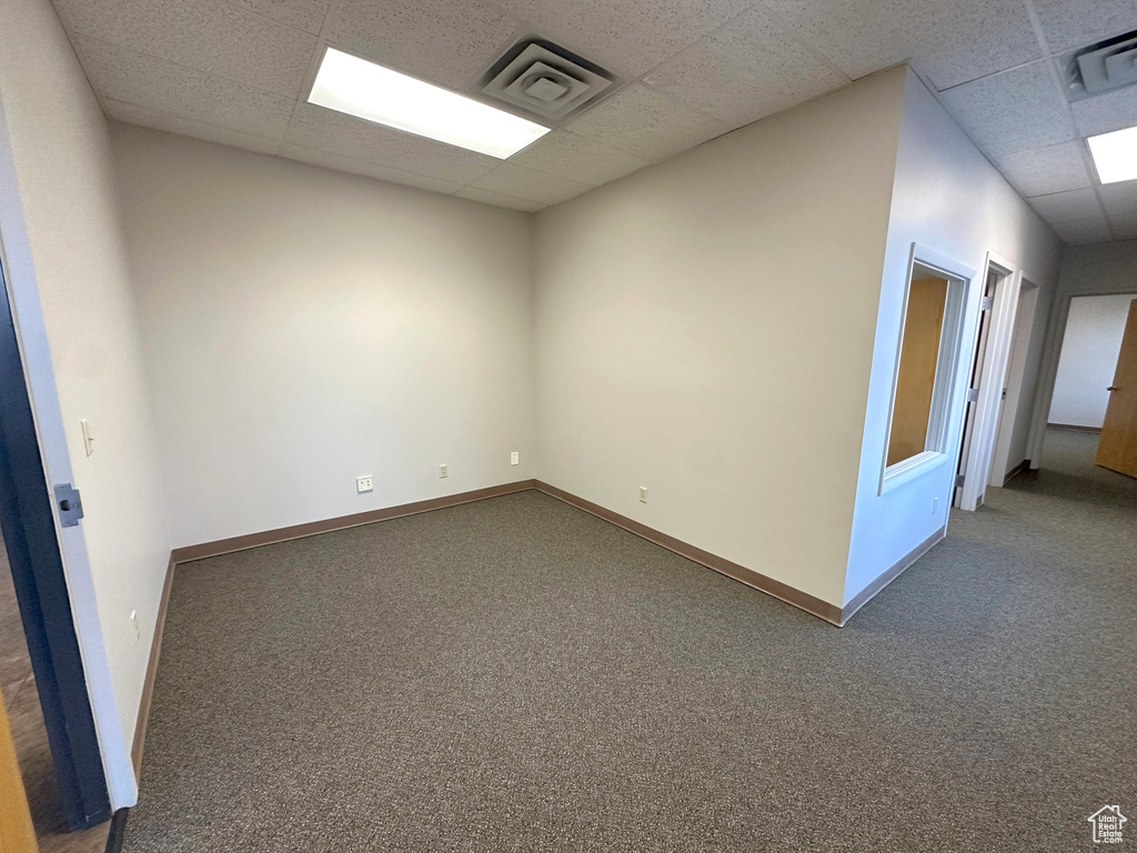 Carpeted empty room featuring a paneled ceiling