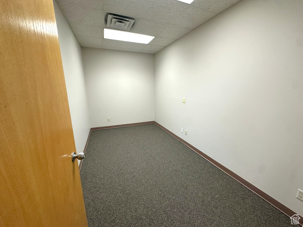 Carpeted empty room featuring a paneled ceiling