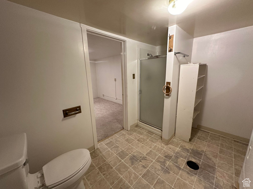 Bathroom with toilet and a shower with shower door