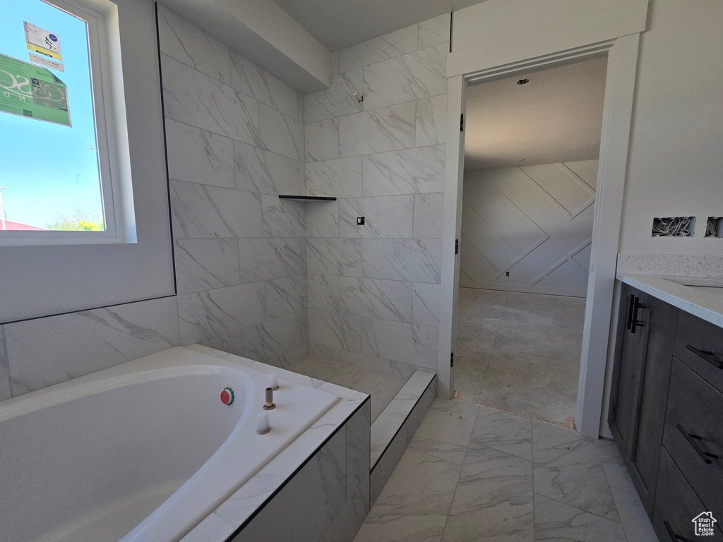 Full bathroom with marble finish floors, a bath, and vanity