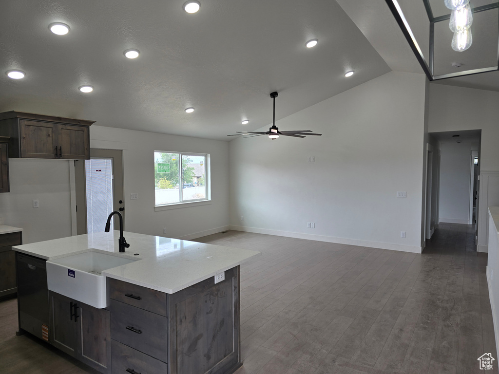 Kitchen featuring a sink, ceiling fan, black dishwasher, lofted ceiling, and baseboards