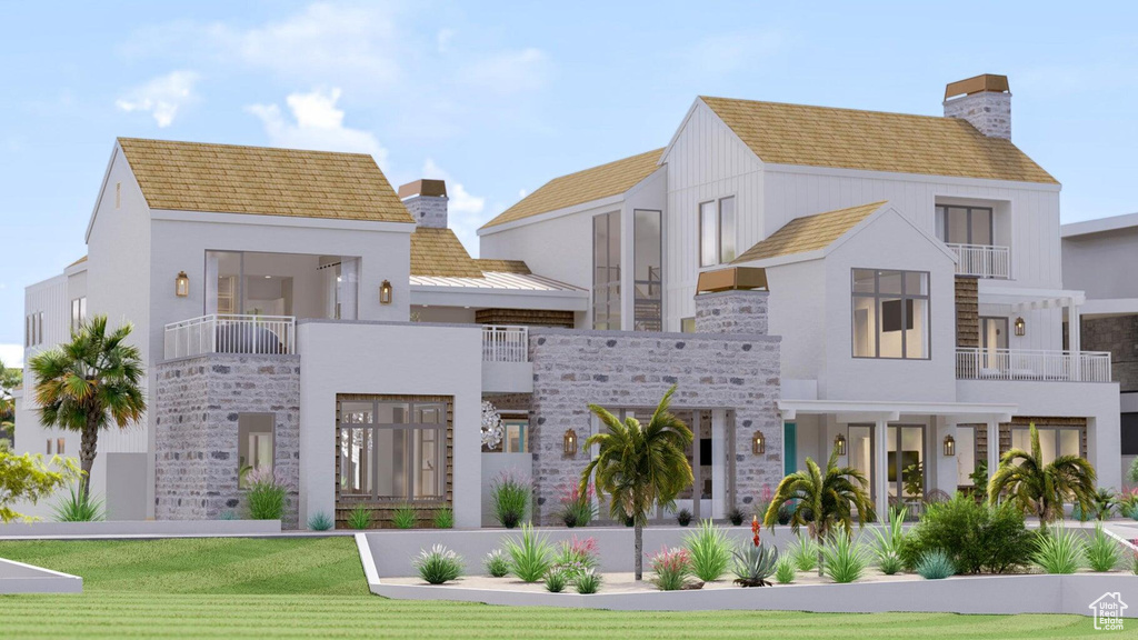 View of front of house with a balcony and a front lawn