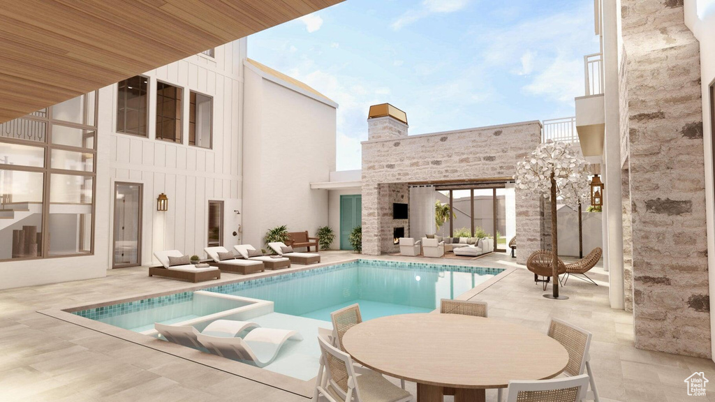 View of pool with an outdoor living space with a fireplace and a patio area