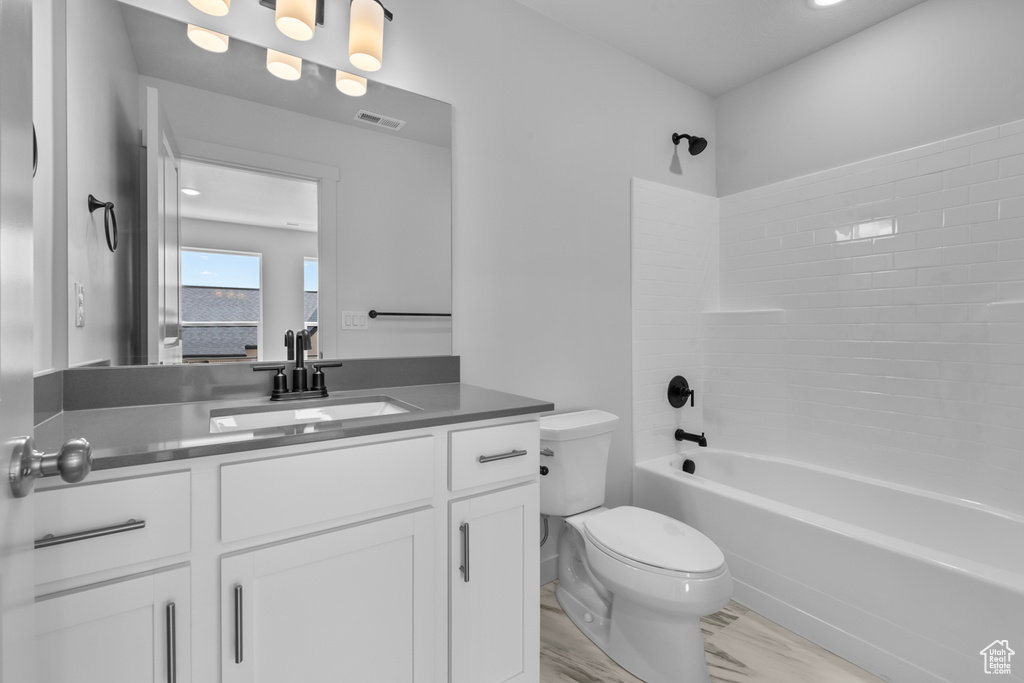 Full bathroom featuring vanity, toilet, and tub / shower combination