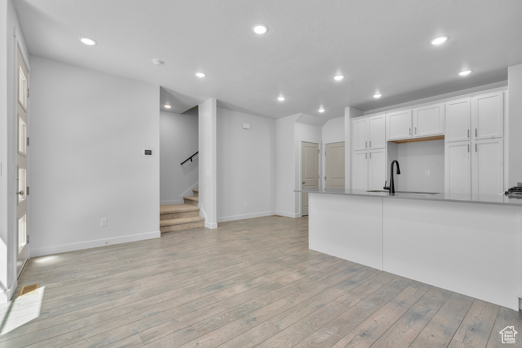 Kitchen featuring white cabinetry, light hardwood / wood-style floors, and sink