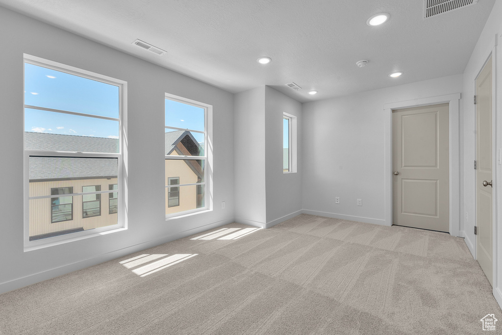 Empty room featuring light carpet