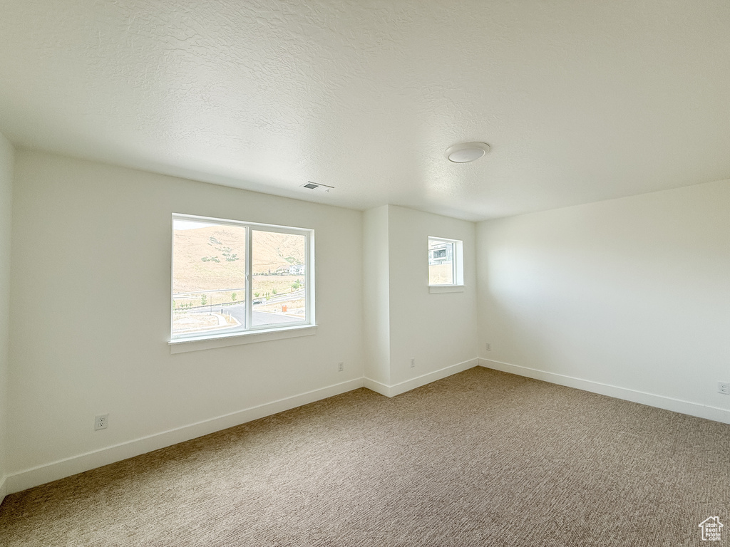 Spare room featuring baseboards and light colored carpet