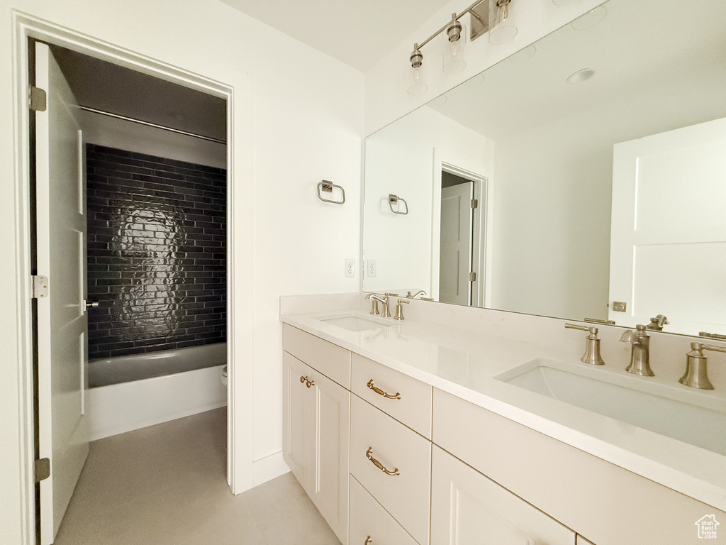 Bathroom featuring double vanity and bathtub / shower combination