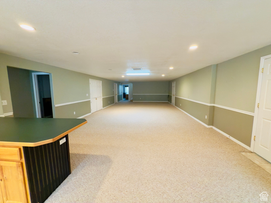 Finished below grade area with recessed lighting and light carpet