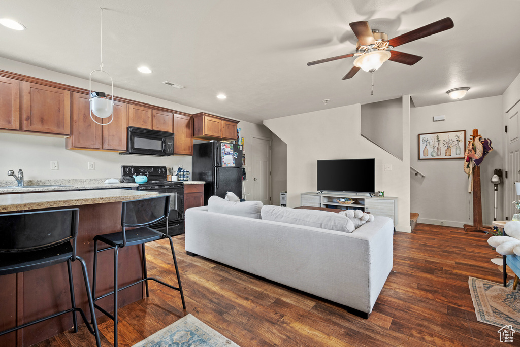 Living area with recessed lighting, dark wood-type flooring, baseboards, visible vents, and ceiling fan