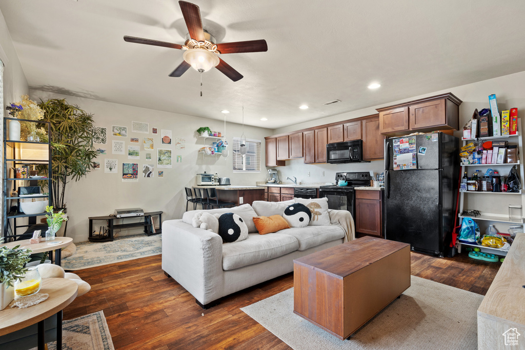 Living room with dark wood-type flooring, ceiling fan, and recessed lighting