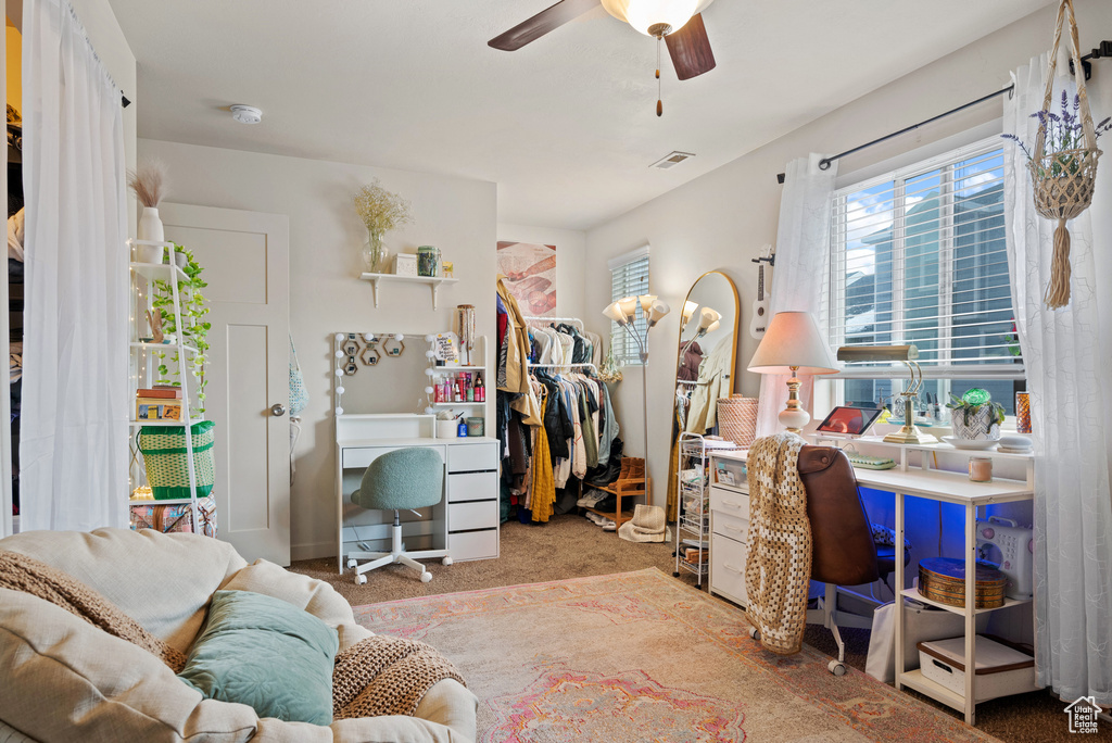 Carpeted office space featuring ceiling fan and visible vents