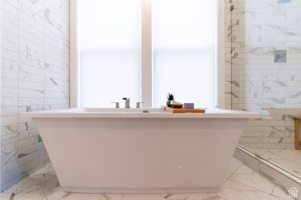 Bathroom with a bathtub and tile walls
