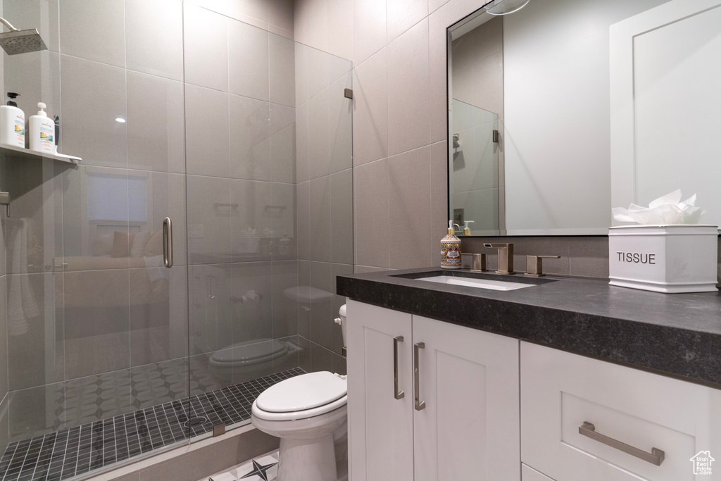 Bathroom with vanity, tile walls, an enclosed shower, and toilet