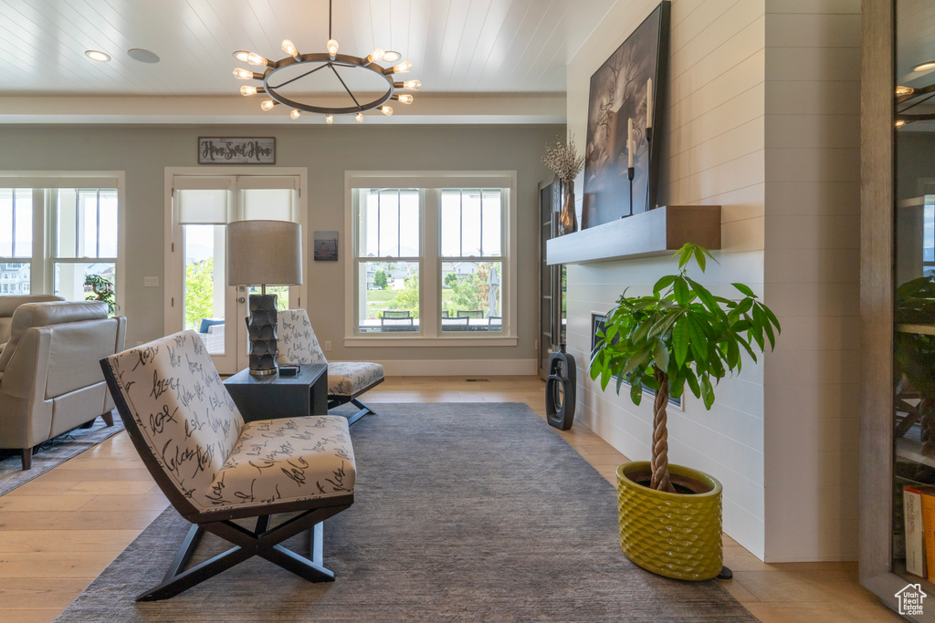 Sitting room with an inviting chandelier, wood ceiling, and light hardwood / wood-style floors