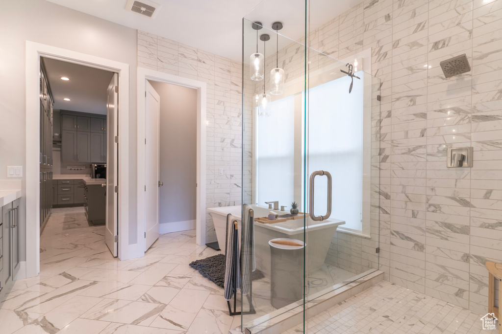 Bathroom featuring vanity and separate shower and tub
