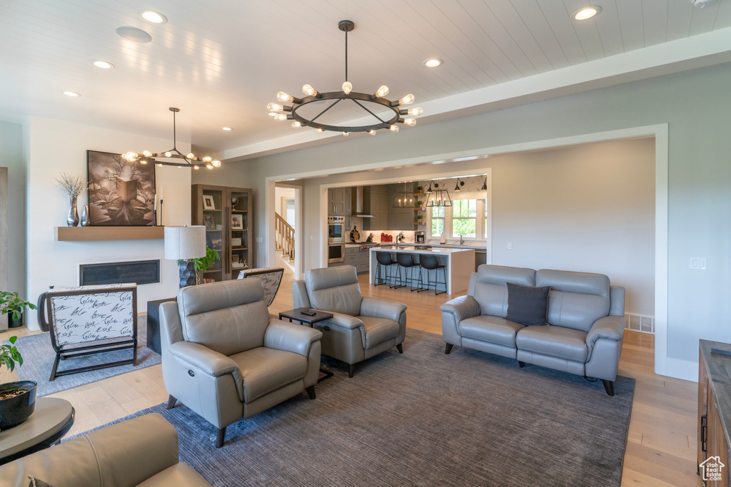 Living room featuring hardwood / wood-style flooring, wood ceiling, and an inviting chandelier