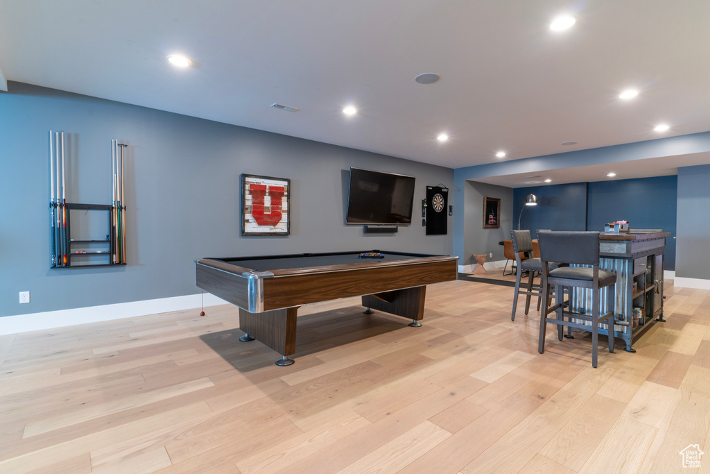 Game room featuring pool table, light hardwood / wood-style floors, and indoor bar