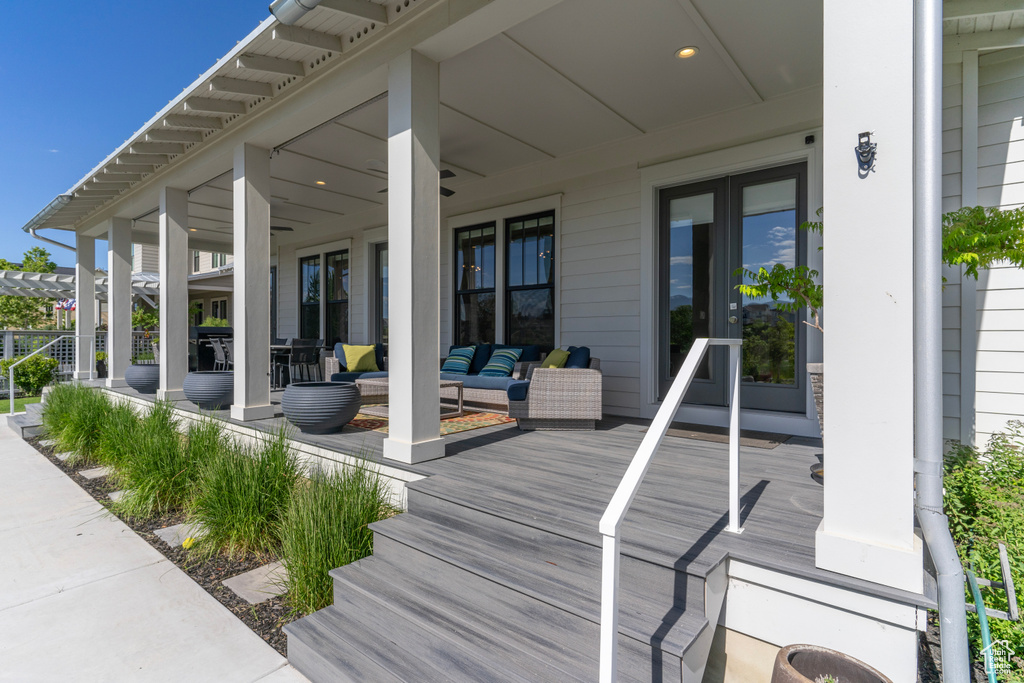 Wooden terrace with a porch, an outdoor hangout area, and ceiling fan