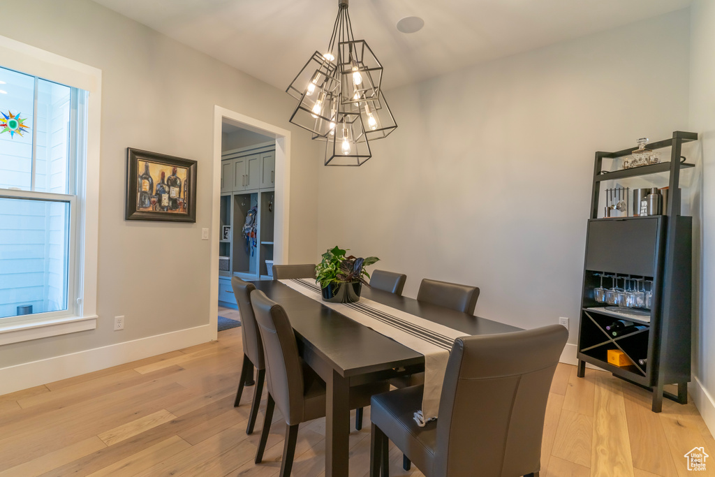 Dining area with a notable chandelier and light hardwood / wood-style flooring