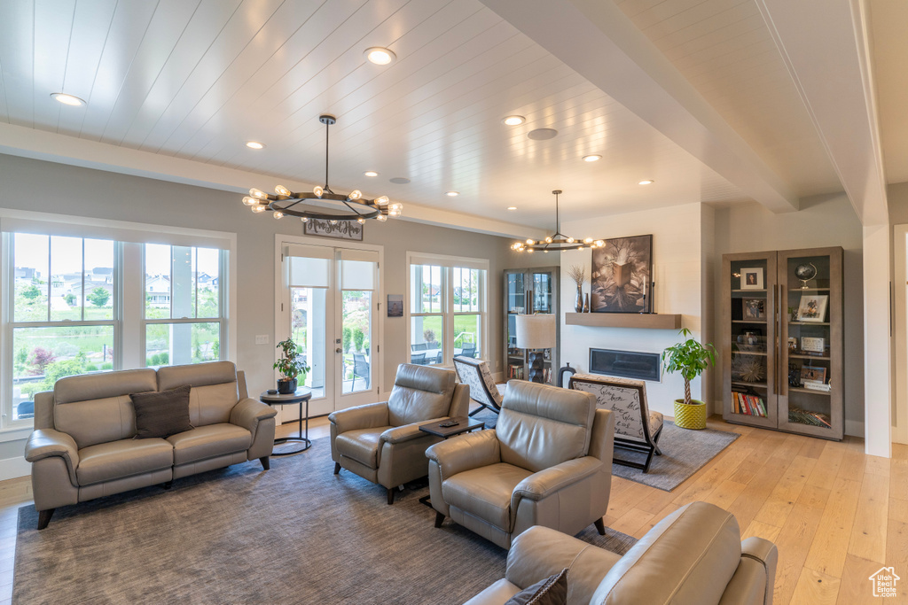 Living room featuring beam ceiling, wooden ceiling, a chandelier, and light hardwood / wood-style flooring