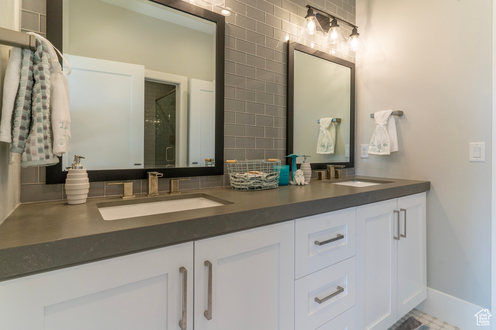 Bathroom with vanity, backsplash, and a shower with shower door