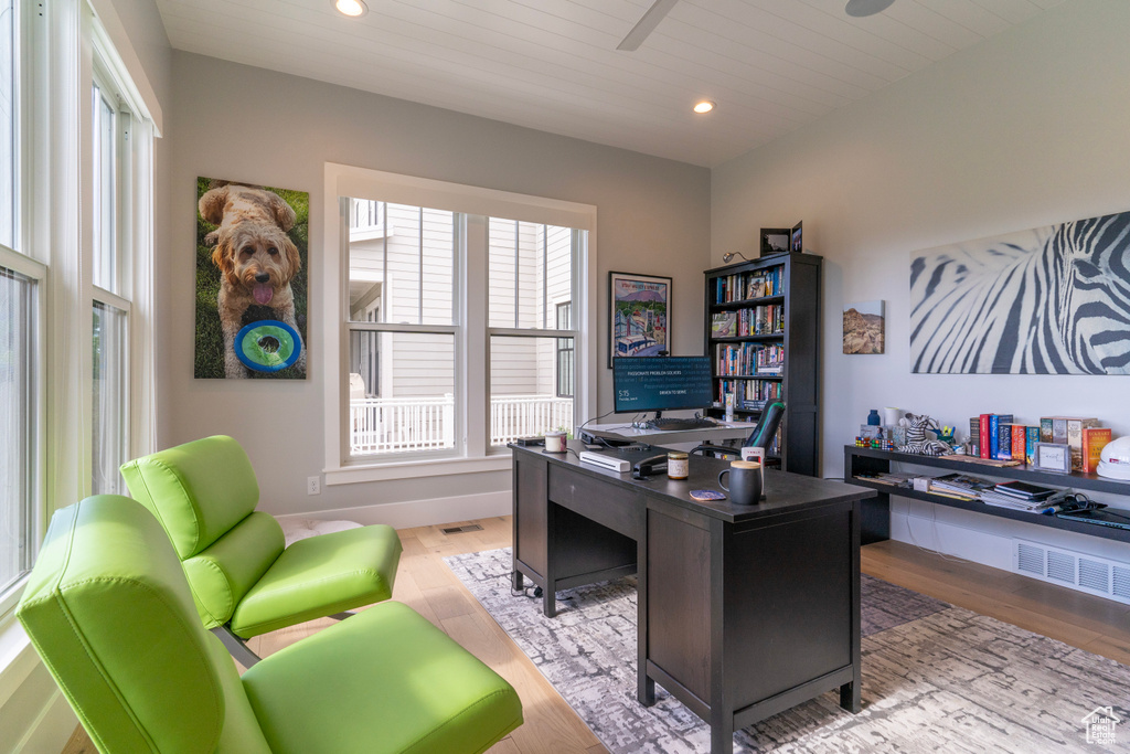 Office area with ceiling fan and light hardwood / wood-style flooring