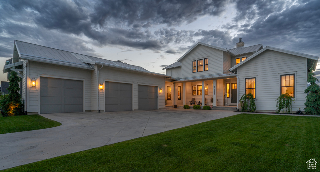 Modern inspired farmhouse featuring a garage and a front yard