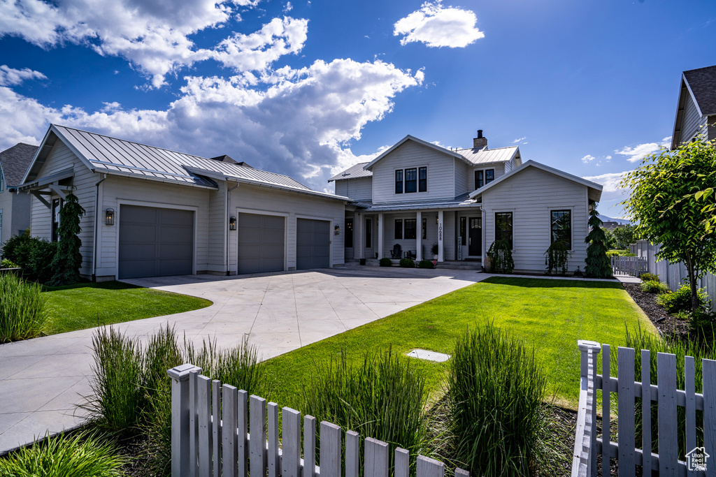 View of front facade with a garage and a front lawn