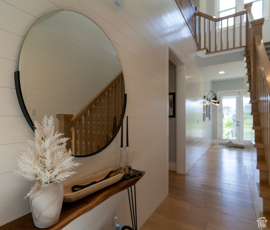 Hall featuring a high ceiling and light wood-type flooring