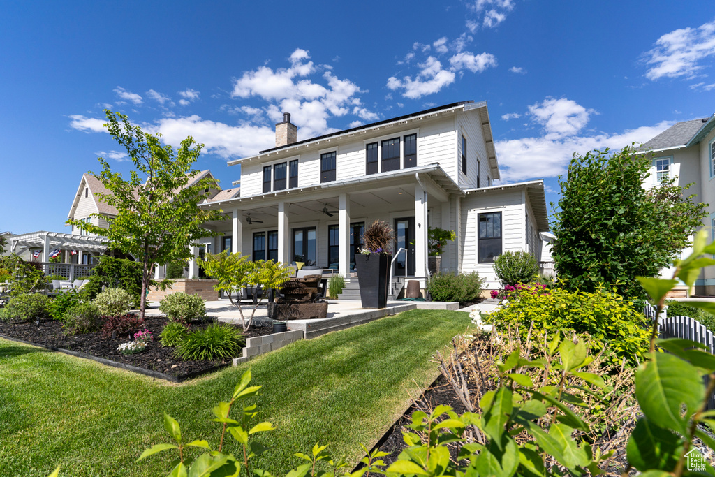 Back of property featuring a pergola, a yard, and ceiling fan