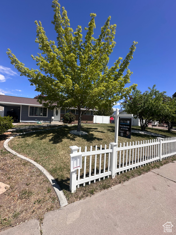 Exterior space with a front lawn and a fenced front yard